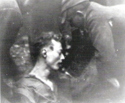 Funkcjonariusze UBP i KBW &quot;pozują&quot; do zdjęcia z wykopanym z grobu ciałem Tadeusza Urbanowicza &quot;Moskito&quot;, październik 1946 r.